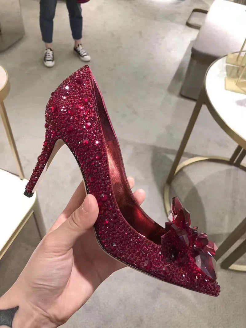 Women's gold pointed toe stiletto heels decorated with rhinestones and a bow