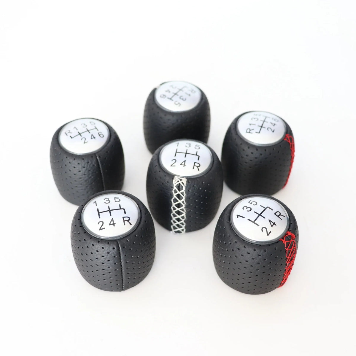 Black perforated PU leather gear knob for Alpha car with sewn seam, shown next to red and white line options.