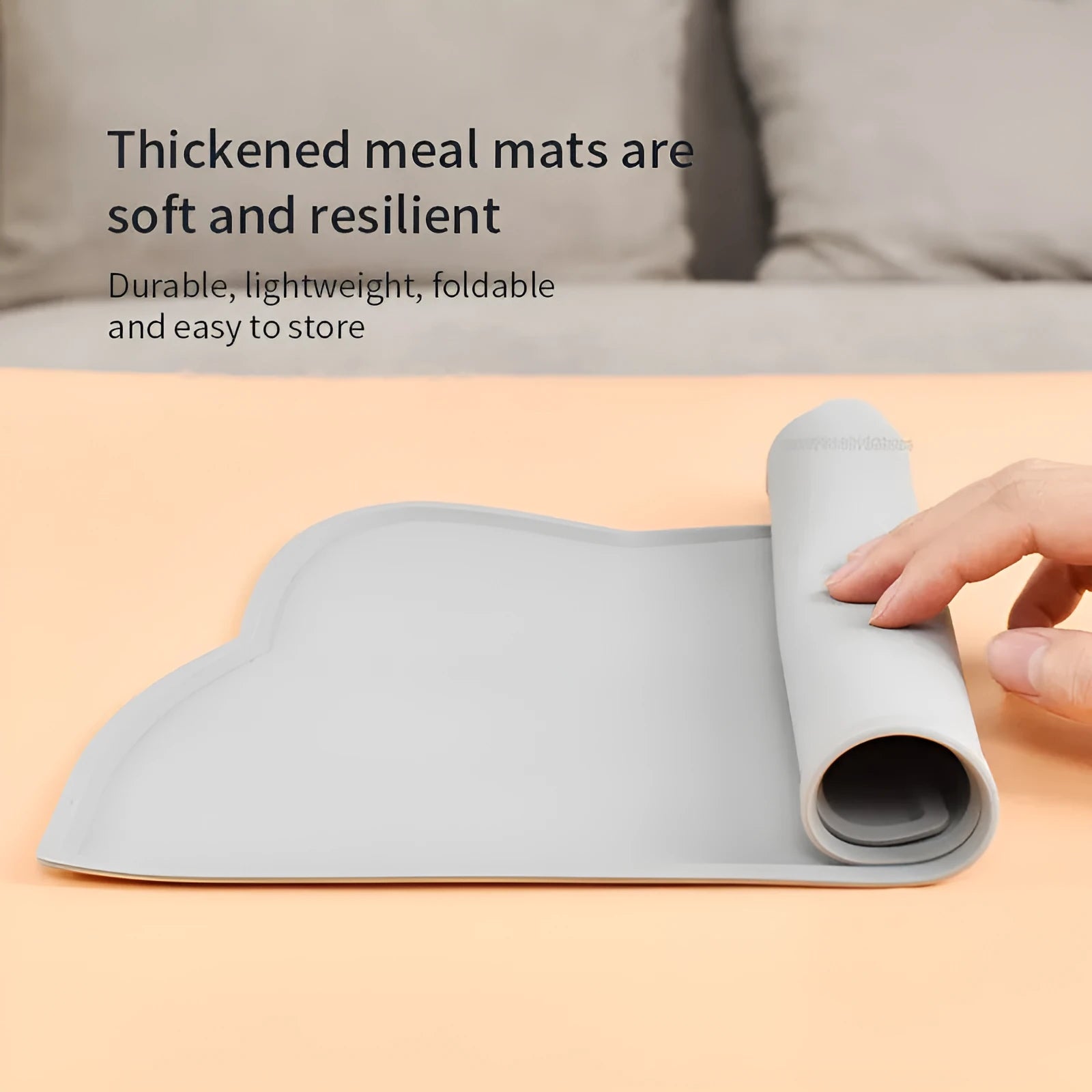 Blue silicone pet feeding mat with cat head shape under food and water bowls.