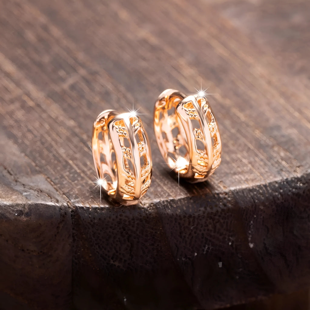 Copper hollowed-out leaf and heart shaped earrings with rose gold finish showing geometric patterns