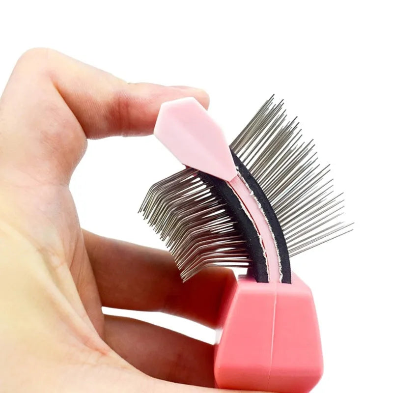 Blue double-sided pet brush with stainless steel pins next to a pink large version on a wooden surface.