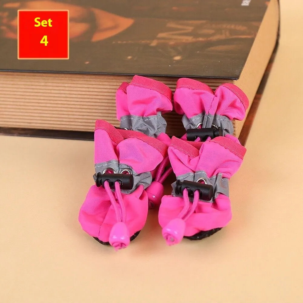 Set of four cloth dog shoes with soft soles in assorted colours on a neutral background