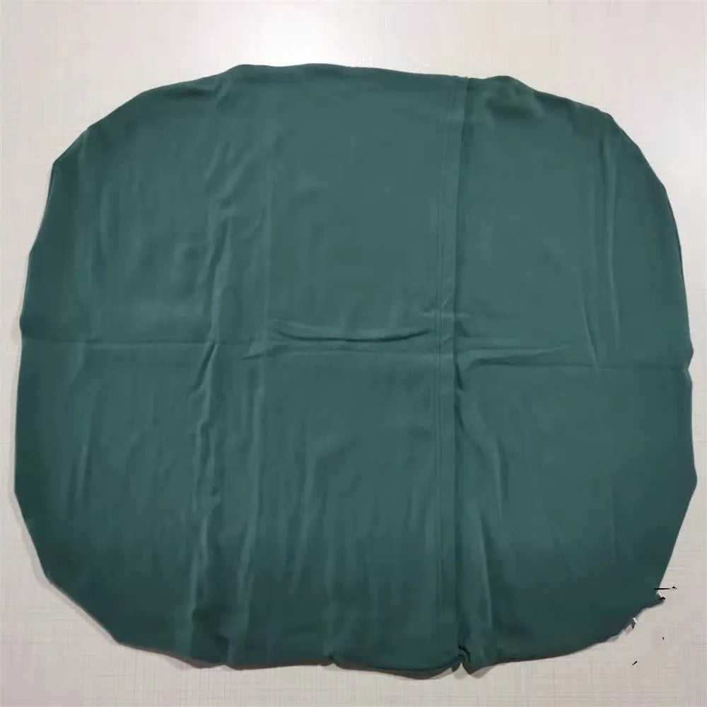 Beige portable cotton baby nest crib for newborn infants on a bed.