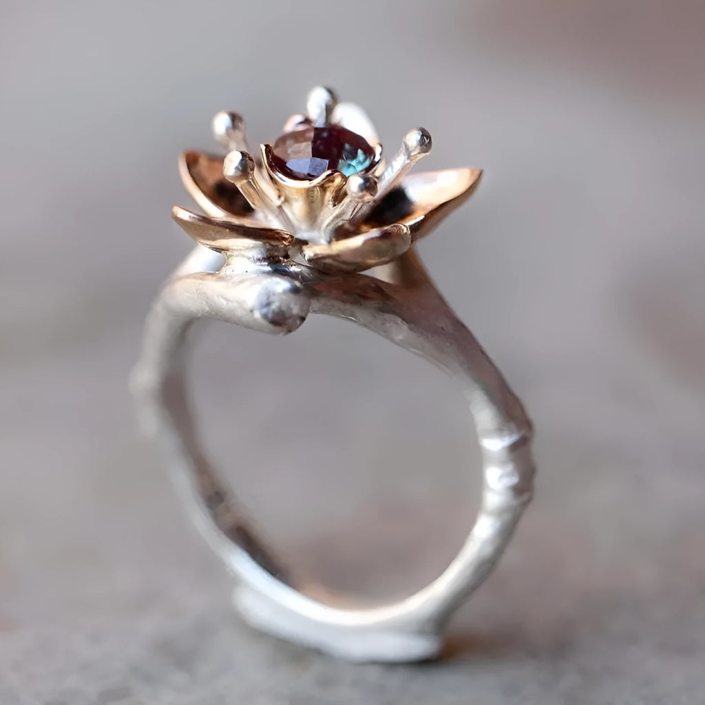 Two-tone silver alloy women's ring with floral geometric design on a flat surface