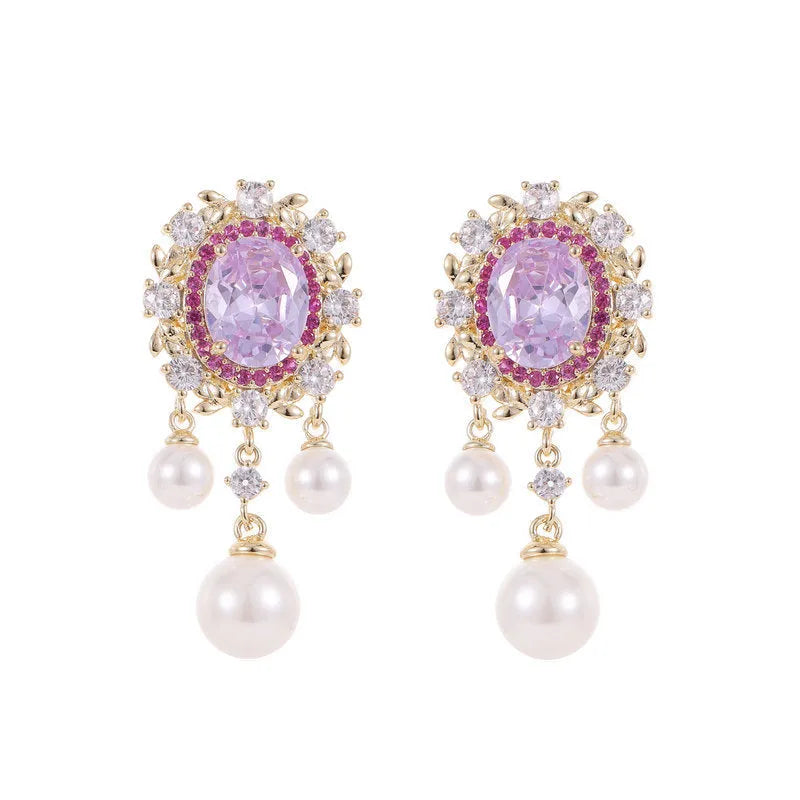 A pair of geometric ellipse-shaped drop earrings with a tassel, featuring pearls and inlaid zircon stones on copper.