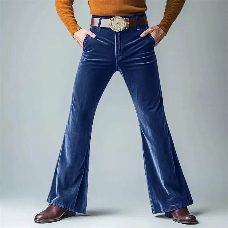 Man wearing gold velvet slim flared suit trousers in dark red for a formal banquet setting.