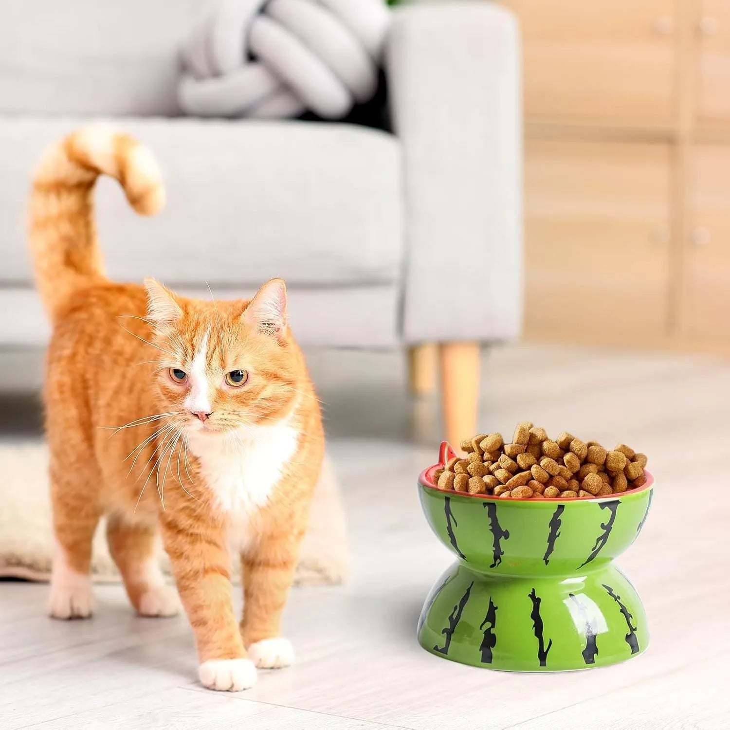 Orange patterned ceramic elevated cat bowl on a wooden floor.
