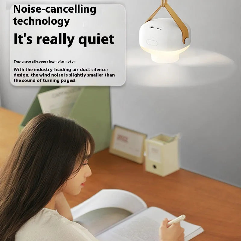 Small white rechargeable ceiling fan with remote control, mounted on a metal wire bracket.