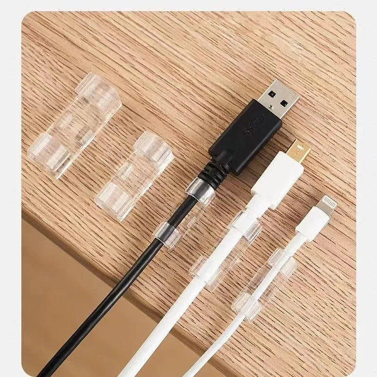 Transparent plastic self-adhesive cable management clips in four sizes on a white background.