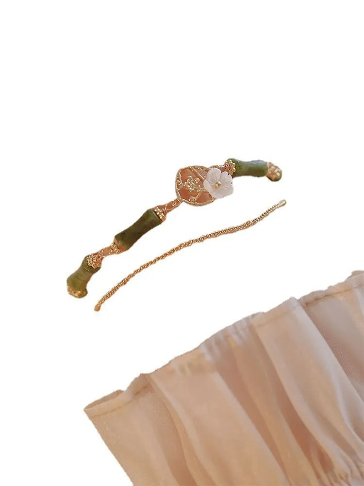 Handcrafted natural olivine bracelet with double layer design and twin Bells of Ireland charms.