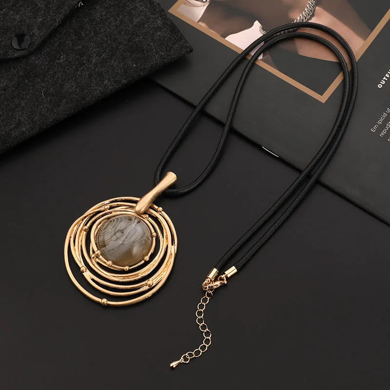 Gold geometric plaid pendant necklace with a textured snakeskin wax rope chain.