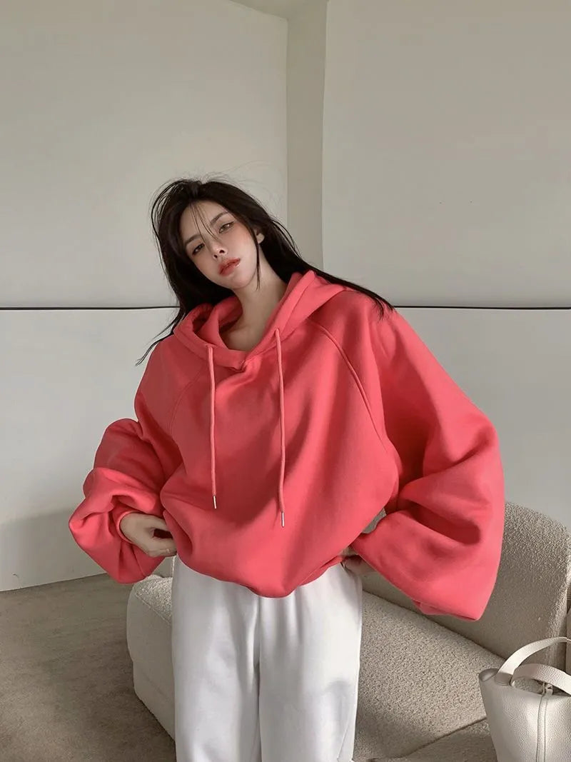 Women's loose watermelon red hooded sweater made from Mulberry Silk, shown on a hanger.