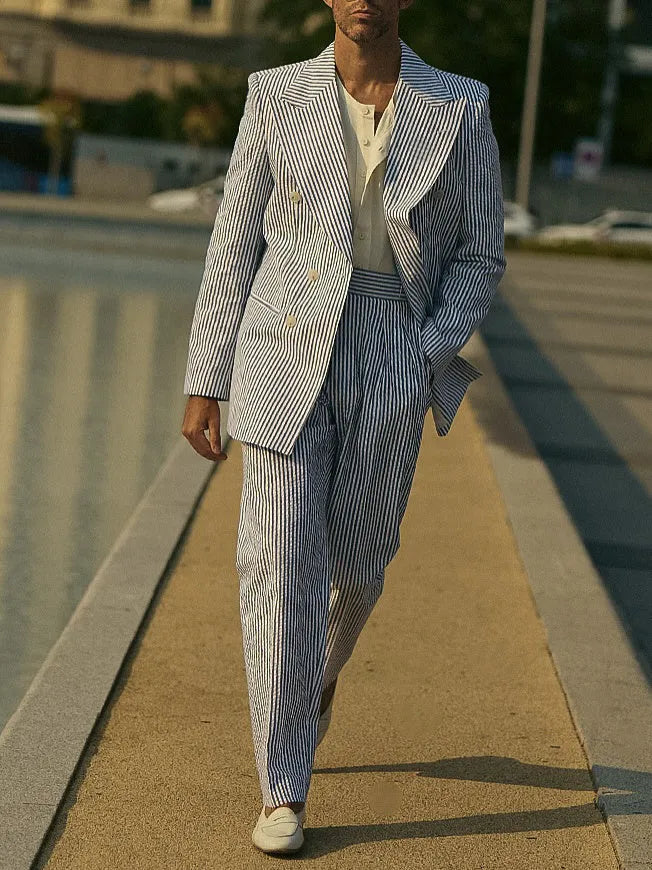 Blue and white striped polyester suit set with blazer and trousers on a hanger.