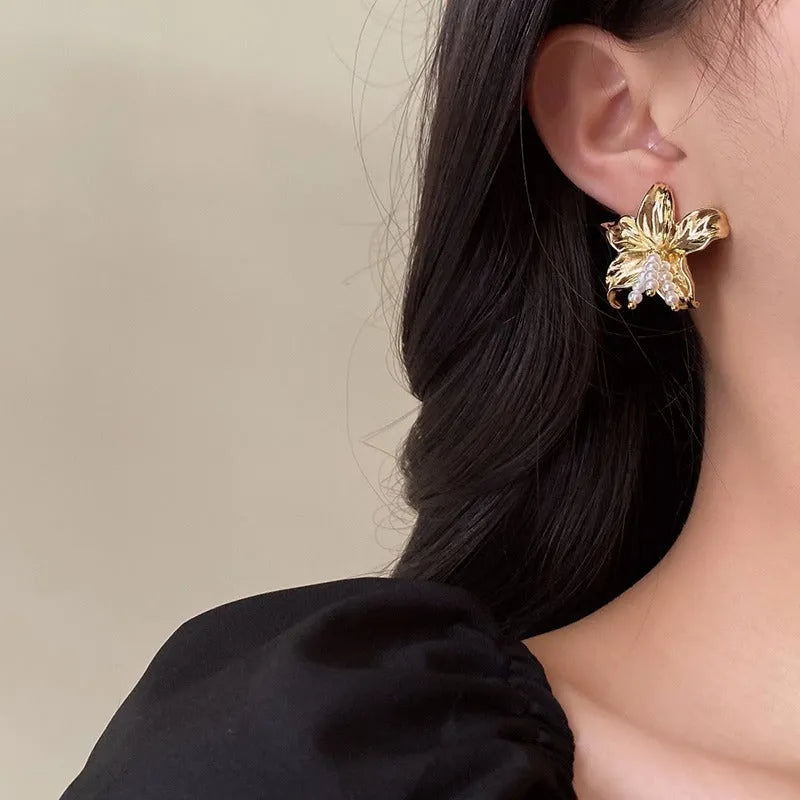 A pair of gold H1795 coloured flower-shaped drop earrings with a pearl centre.