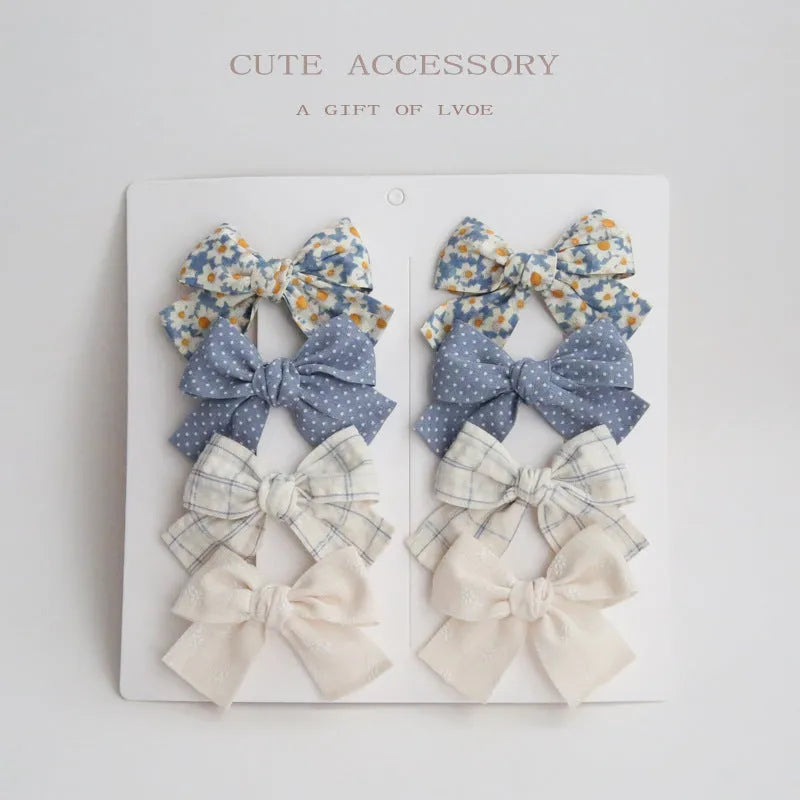 Children's dovetail bow hairclips in eight colour patterns including grid dots and floral designs