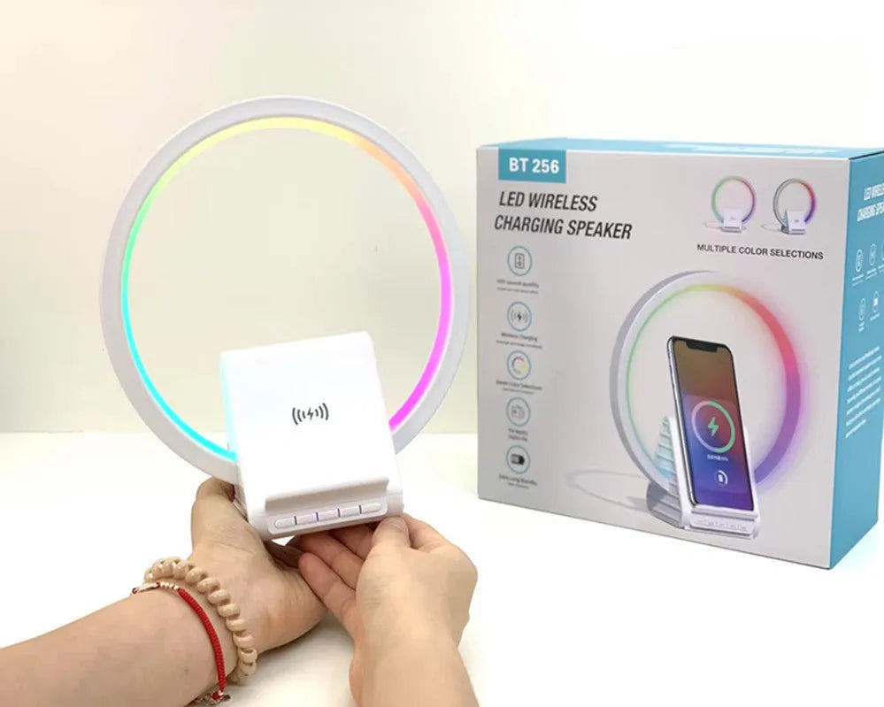 White smart Bluetooth speaker with wireless charging pad and ambient light on top.