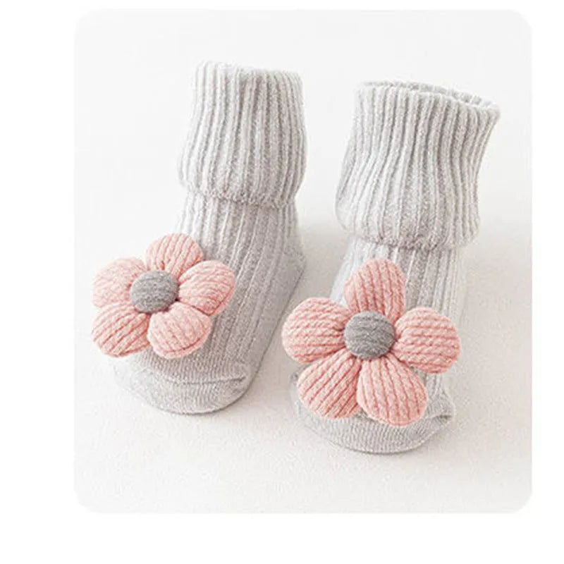 Cotton baby floor socks in various designs including blue bow and lion, showing sizes for infants 0-3 months