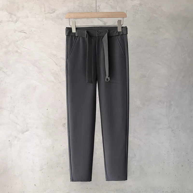Boys slim straight-leg wool trousers in tapered cut, shown in black, on a hanger.