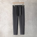 Boys slim straight-leg wool trousers in tapered cut, shown in black, on a hanger.