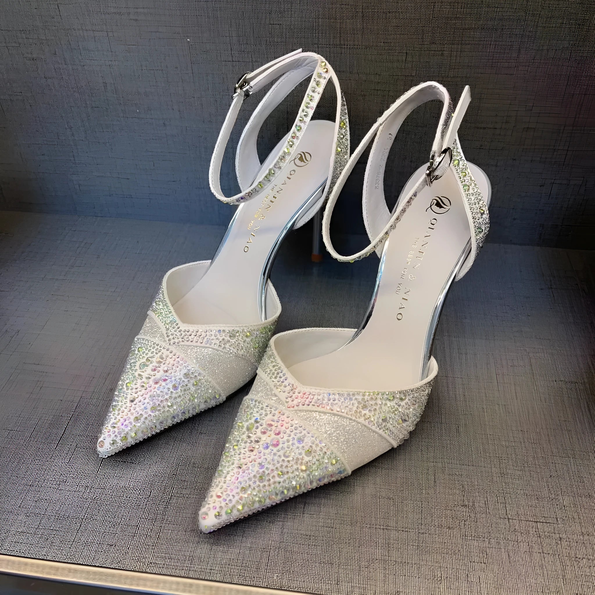 Women's black and silver hollow-cut stiletto high heels with pointed toes and red soles.