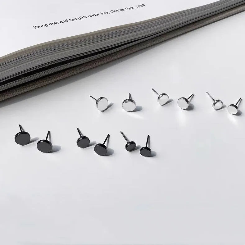 A pair of round, flat S999 sterling silver bone stud earrings on a plain background.