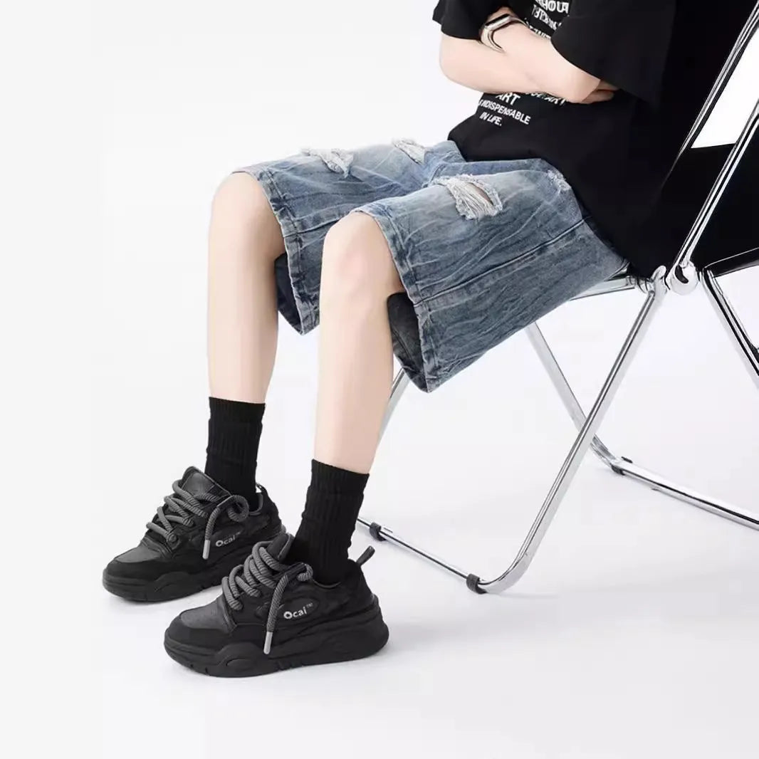 Loose-fit denim shorts with a washed fabric finish and ripped, distressed detailing on the legs.