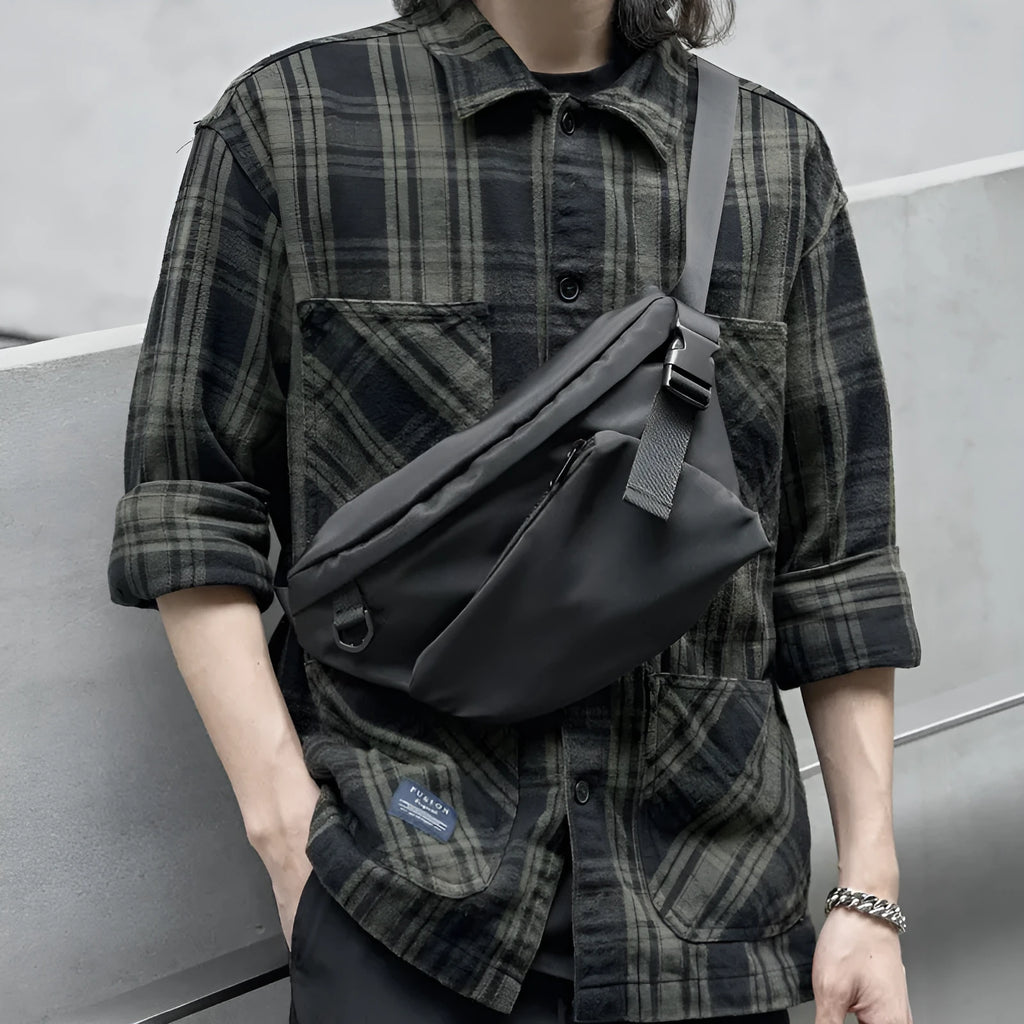Black men's slanted chest bag in Oxford fabric with visible stitching, shown worn across the chest.