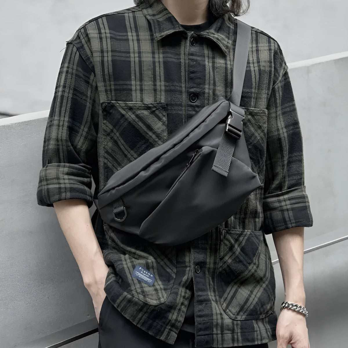 Black men's slanted chest bag in Oxford fabric with visible stitching, shown worn across the chest.