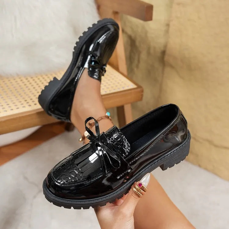 Brown women's pointed-toe loafers with a fabric bow detail on the vamp.