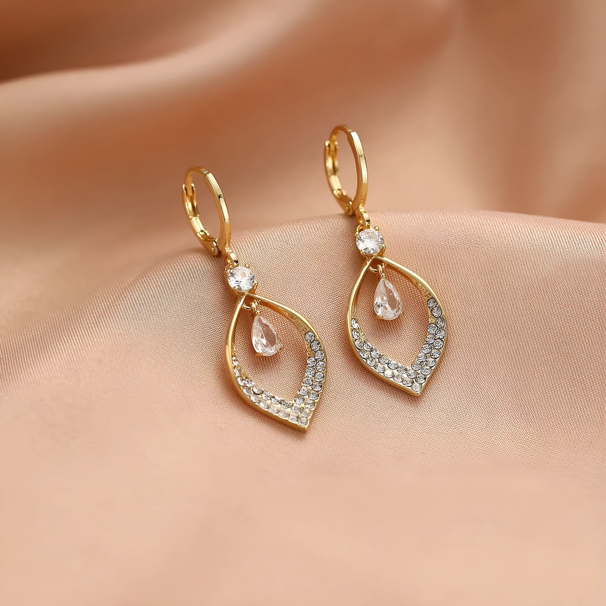 Copper tear-drop shaped earrings with zircon detailing and tassel finish, showing gold and silver electroplated buckle options