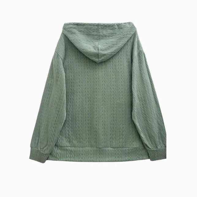Green women's hooded sweater coat with front zipper, shown on a model in a casual setting.