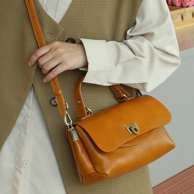Women's brown leather saddle handbag with open outer pocket and double shoulder straps