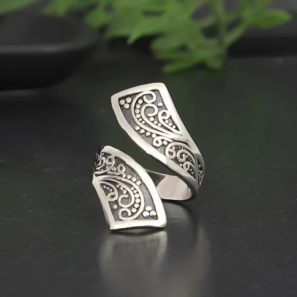 Silver-coloured adjustable opening women's ring with a retro minimalist style on a grey background.
