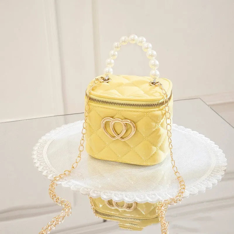 White PVC bucket-shaped cosmetic bag with a red heart pattern, zipper open.