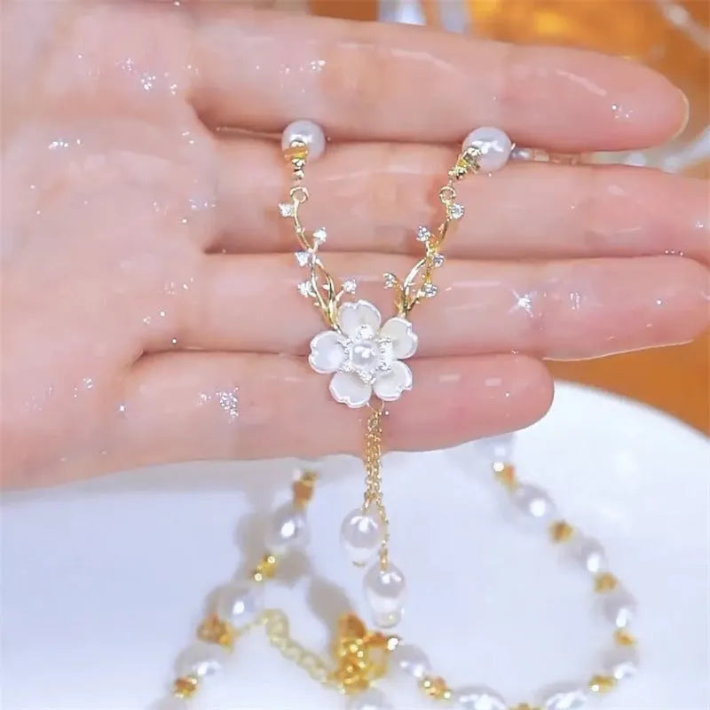 Alloy fashion necklace with pearl flower and rose decoration on a chain.