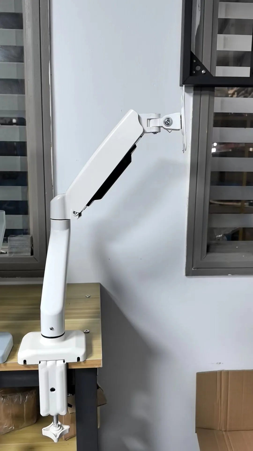 Black rotating telescopic monitor bracket on table with screen adjustment demonstration