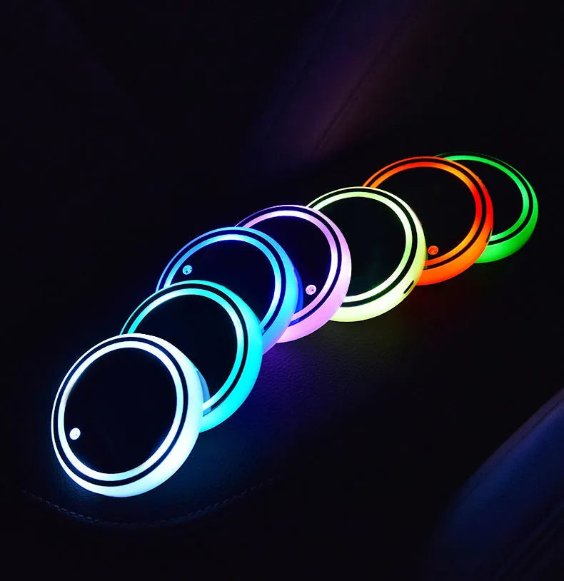 Colourful LED light-up coaster for car cup holder showing multiple light colours on a dark surface.