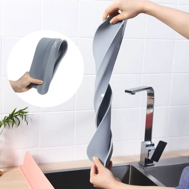 A thick grey silicone water blocking plate for a kitchen sink, shown next to a sink edge.