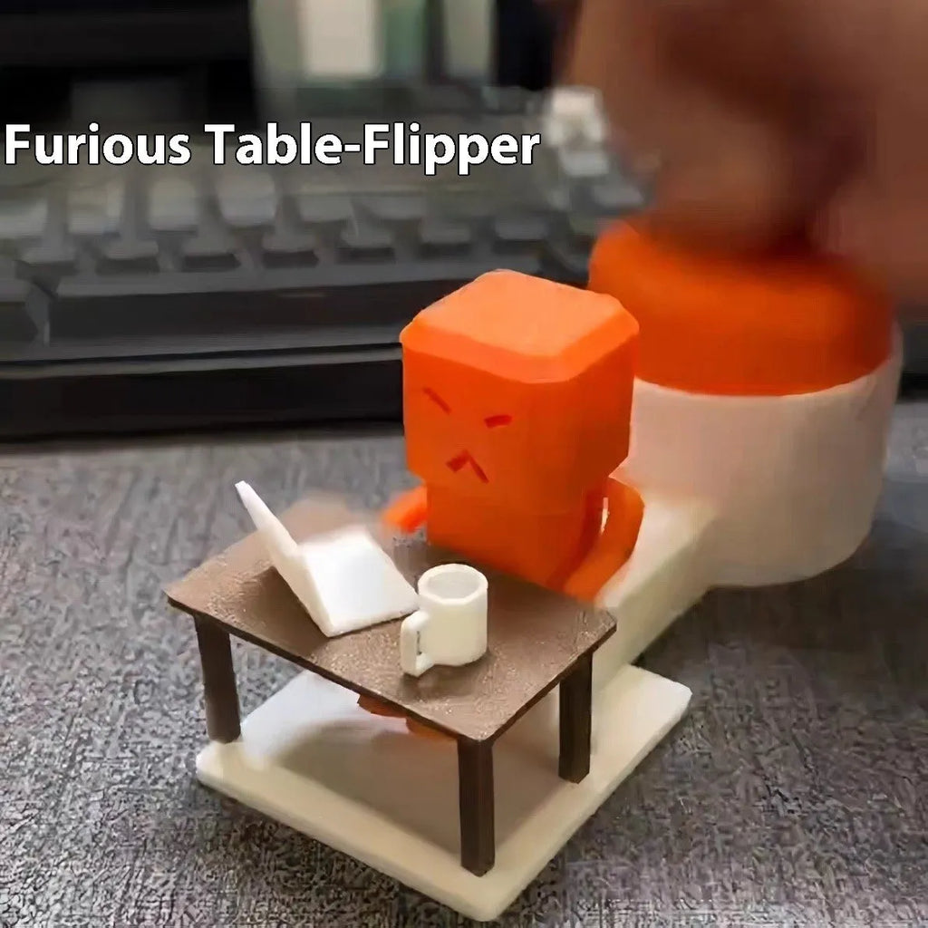 Orange plastic table-turning decompression toy on a desk.