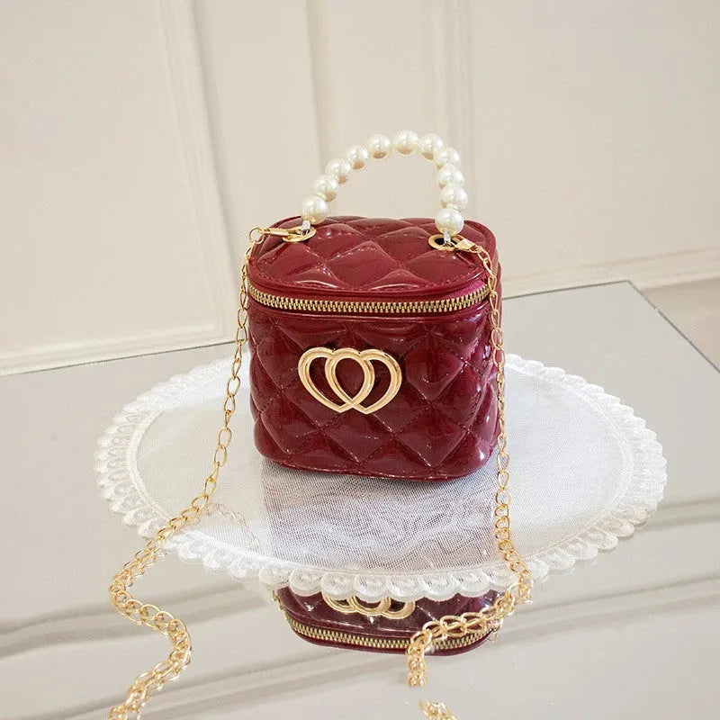 White PVC bucket-shaped cosmetic bag with a red heart pattern, zipper open.