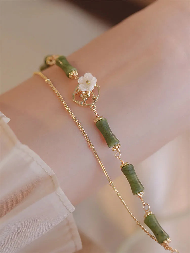Handcrafted natural olivine bracelet with double layer design and twin Bells of Ireland charms.