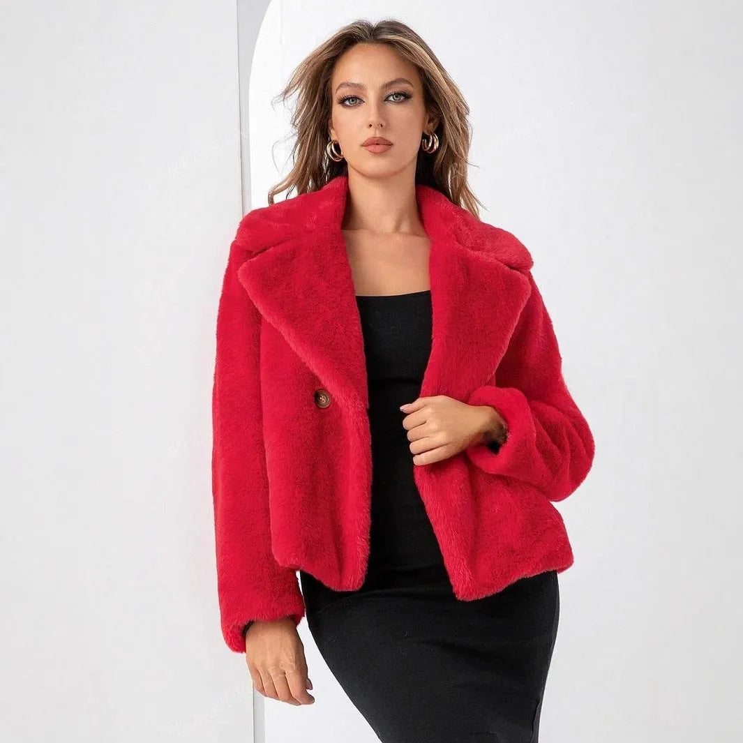 A rose red women's short faux fur coat with a loose fit and regular sleeves on a hanger.